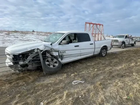 Accident-damaged vehicle being carefully loaded onto a tow truck