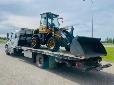 Equipment hauling service moving small machinery in Strathmore.