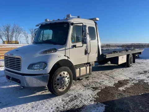 Flatbed tow truck loading a vehicle in Strathmore