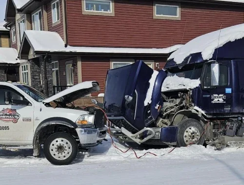 Flatbed tow truck transporting a vehicle for a longer-distance towing job across Alberta.