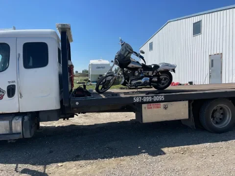 Tow truck prepared to move a motorcycle in Southwest Calgary