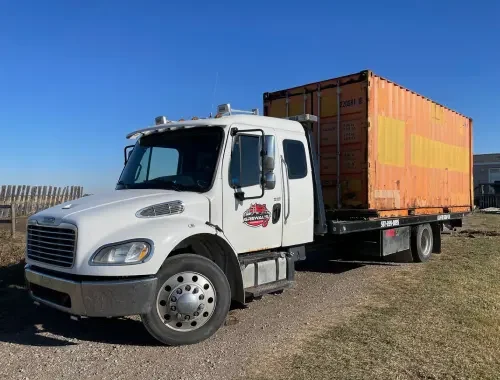 Southwest Calgary flatbed tow truck carrying a vehicle
