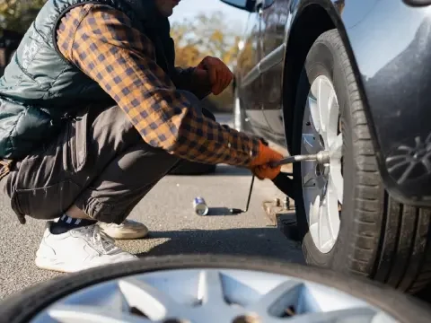 Tire change service helping a driver with a flat tire in Strathmore.