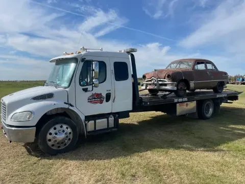 Vehicle recovery tow truck assisting a stuck vehicle in Strathmore