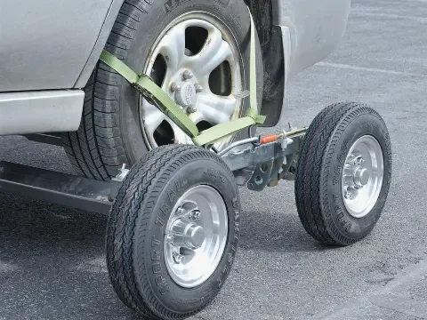 Wrecker tow truck with dollies assisting a vehicle in Chestermere