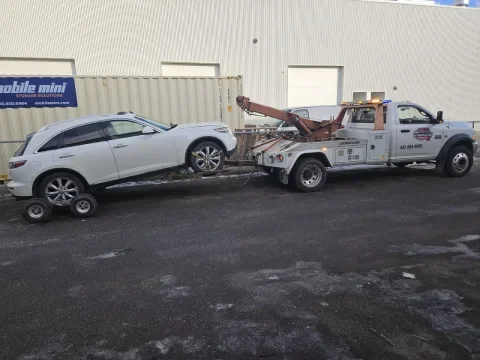 Wrecker tow truck using dollies for a damaged vehicle